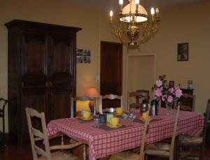 mesa de comedor con mantel a cuadros rojo y blanco en Le Manoir du Butel, en Saint-Amand