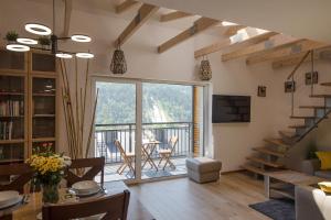 a living room with a large window and a dining room at Apartamenty Słoneczna Góra w spokojnej okolicy - Dream Apart in Szczyrk