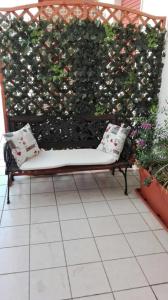 a bench with two pillows sitting in front of a hedge at A casa di Gio’ in Marsala