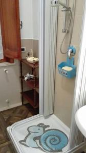 a bathroom with a shower with a monkey on the floor at A casa di Gio’ in Marsala
