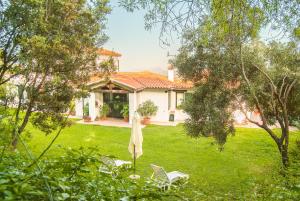 a house with two chairs and a umbrella in the yard at Villa Aurora in Olbia +36 photos