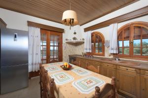 een keuken met een tafel en een fruitschaal bij Villa Valasia in Gennadi
