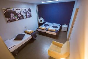 バルセロナにあるドン マスタッシュ ブティック ホステルのベッド2台と椅子が備わる小さな客室です。