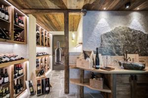 - une salle de dégustation de vin avec des bouteilles de vin sur les étagères dans l'établissement Hotel Ciamp, à Santa Cristina Valgardena