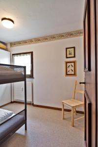 ツェエリーナにあるChesa Chavriol 2 - Celerinaのベッドルーム1室(二段ベッド2台、椅子付)