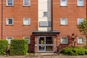 坎诺克Chapel Court Apartments的门上带有书记官庭标志的砖砌建筑