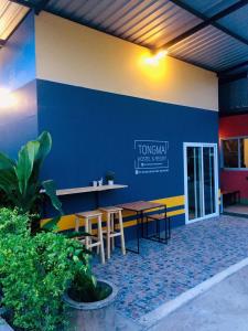 un restaurant avec des tables et des chaises et un mur bleu dans l'établissement Tongmai Resort, à Surat Thani