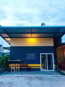 un bâtiment bleu et blanc avec un banc devant dans l'établissement Tongmai Resort, à Surat Thani