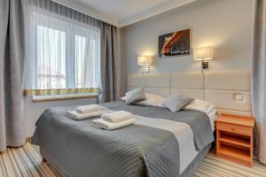a bedroom with a bed with two towels on it at Aster in Władysławowo