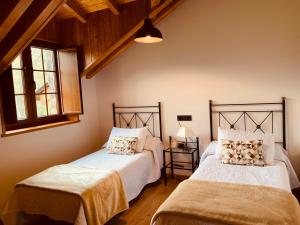 two beds in a room with two windows at Casa Lixa Hotel Rural Albergue in Las Herrerías