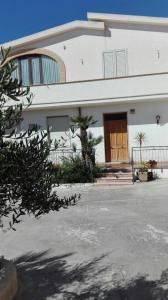 Casa blanca grande con puerta de madera en A casa di Gio’, en Marsala