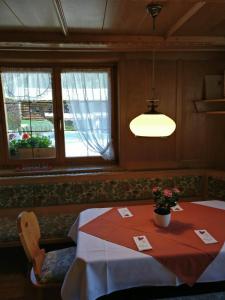 a dining room with a table and a light at Frühstückspension Gweil in Sankt Gallenkirch