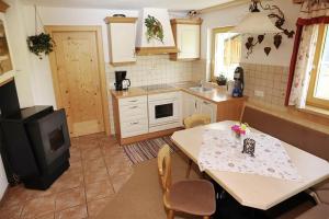 a kitchen with a table with chairs and a stove at Haus zur Kapelle in Sankt Gallenkirch