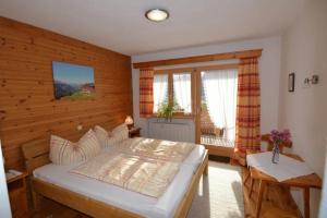 a bedroom with a large bed and a window at Haus Marent in Bartholomäberg