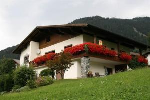 ein Haus mit roten Blumen auf der Seite in der Unterkunft Haus Simone - Tschofen Waltraud in Sankt Gallenkirch