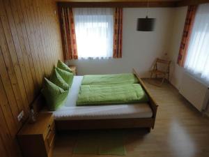 una camera da letto con letto con lenzuola verdi e finestra di Schöllhorn Judith a Sankt Gallenkirch