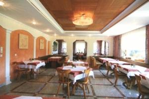 a restaurant with tables and chairs in a room at Hotel Lenzenhof in Oberau