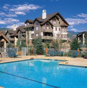 a large house with a swimming pool in front of it at 2Br- Arrowhead Village- Great Location And Gorgeous Condo Condo in Beaver Creek