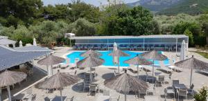 een groep parasols en stoelen naast een zwembad bij Hotel Zafira in Skala Rachoniou