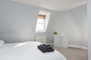a white bedroom with a white bed and a dresser at Camden Apartment E/Apartment in London