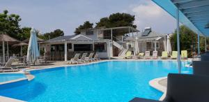 a large swimming pool with chairs and umbrellas at Hotel Zafira in Skala Rachoniou