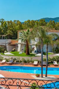 a resort with a swimming pool and palm trees at Corte Bianca - Adults Only & SPA - Bovis Hotels in Cardedu