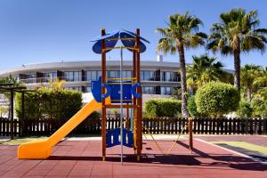 um parque infantil com um escorrega em frente a um edifício em Pestana Vila Sol Golf & Resort Hotel em Vilamoura