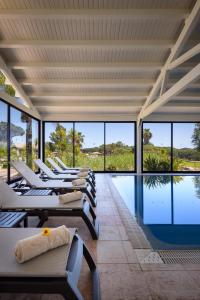 una fila di sedie a sdraio accanto alla piscina di Pestana Vila Sol Golf & Resort Hotel a Vilamoura