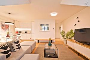 uma sala de estar com um sofá e uma televisão em Penthouse with River View - Baixa Alfama em Lisboa