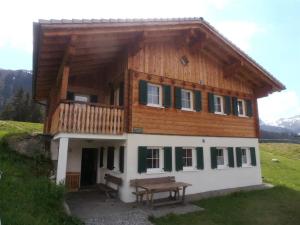 ein Holzhaus mit einer Bank davor in der Unterkunft Haus zur Kapelle in Sankt Gallenkirch