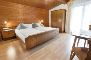 a bedroom with a large bed and a wooden wall at Rudigier Margret und Franz in Sankt Gallenkirch
