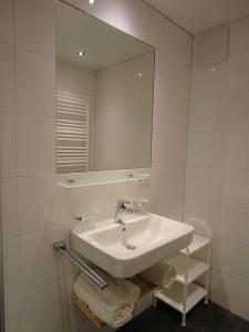 een witte badkamer met een wastafel en een spiegel bij Schöllhorn Judith in Sankt Gallenkirch