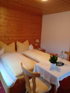 a hotel room with a bed and a table with a flower on it at Frühstückspension Gweil in Sankt Gallenkirch
