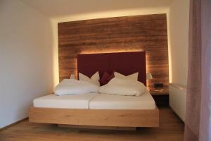 a bed with two pillows on it in a room at Haus Ender in Sankt Gallenkirch