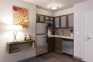 a kitchen with a refrigerator and a table with a lamp at Staybridge Suites Charlottesville Airport, an IHG Hotel in Charlottesville