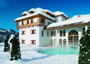 a house in the snow with a swimming pool at A-ROSA Kitzbühel in Kitzbühel