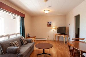 a living room with a couch and a table and a tv at Dutch Inn in Cornwall