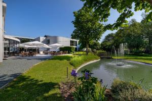 a pond in front of a building with a fountain at Hotel Ter Elst in Edegem