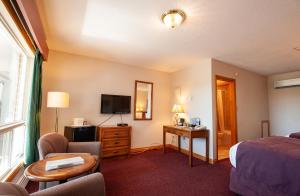 une chambre d'hôtel avec un lit et une télévision dans l'établissement Dutch Inn, à Cornwall