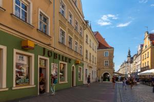 Un grupo de personas caminando por una calle con edificios. en Silver Vision Apartment - Rynek, en Opole
