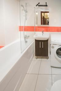 Un baño blanco con bañera y lavabo. en Silver Vision Apartment - Rynek, en Opole