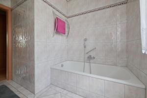 een badkamer met een bad en een roze handdoek bij Ferienwohnung AOLI in Gmunden
