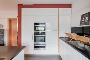een witte keuken met twee ovens aan de muur bij Ferienwohnung AOLI in Gmunden