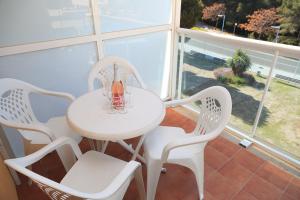 a white table and chairs in a room with a window at UHC Bellavista Apartments in Salou