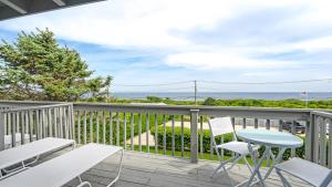 uma varanda com uma mesa e cadeiras e o oceano em Beach Plum Resort em Montauk