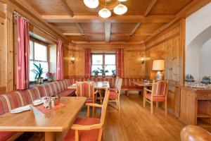 a restaurant with wooden walls and tables and chairs at Hotel Alpenhof in Bad Hofgastein