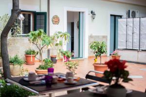 un patio con una mesa con flores y plantas en Callas Room Opera, en Catania