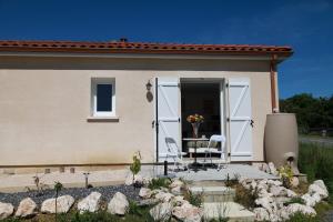 a house with two chairs and a table in front of it at Villa Marcus in Castelnau-Magnoac