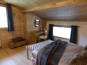 Schlafzimmer mit Holzwänden, einem Bett und einem Fenster in der Unterkunft Les Chalets Aquarelle in Chamonix-Mont-Blanc