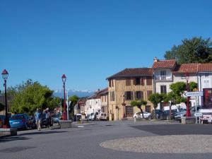 a street in a town with cars and buildings at Villa Marcus in Castelnau-Magnoac